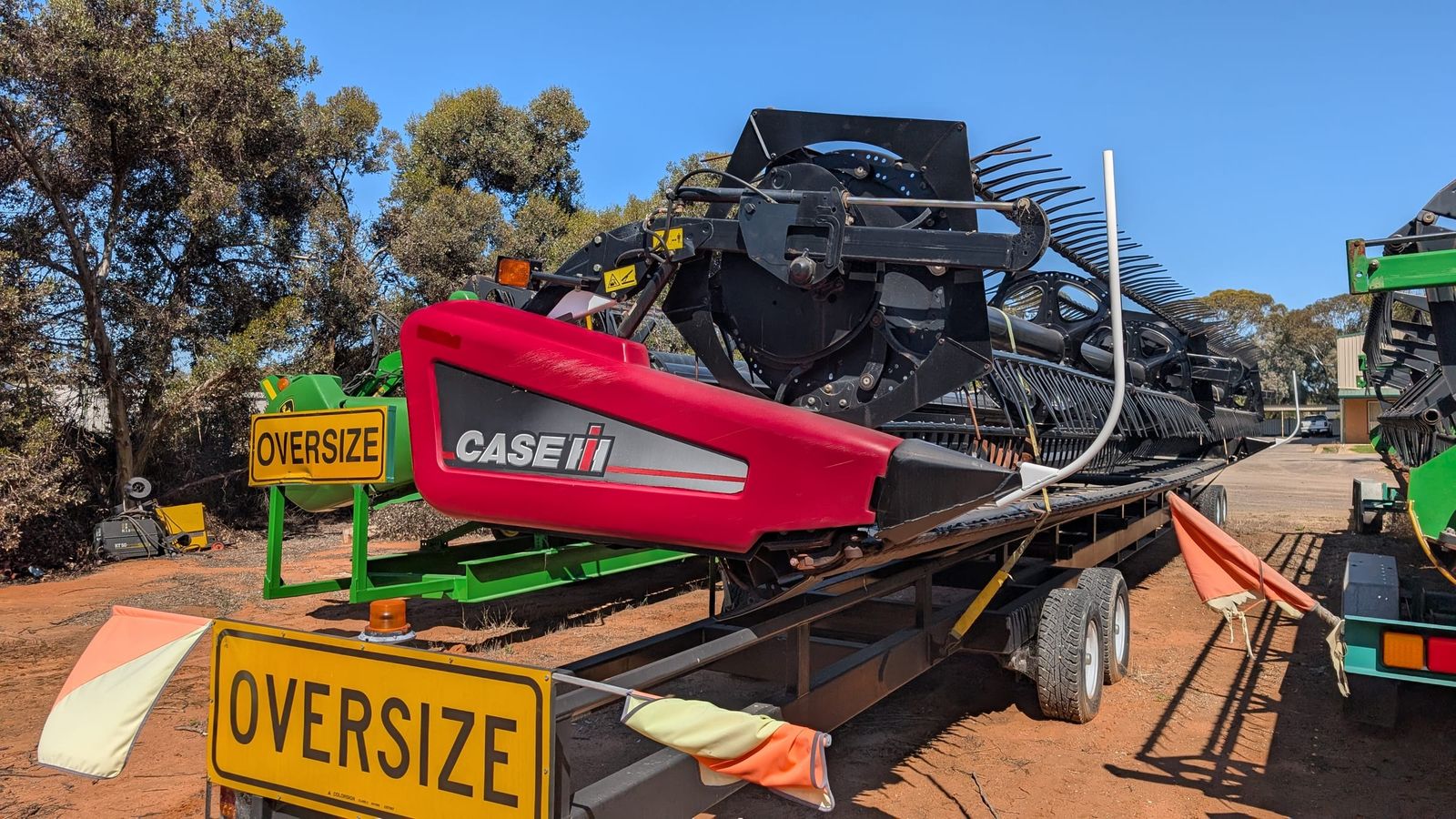 MacDon D60 40ft draper front loaded on its transport trailer, front quarter view in the HFR yard at Swan Hill