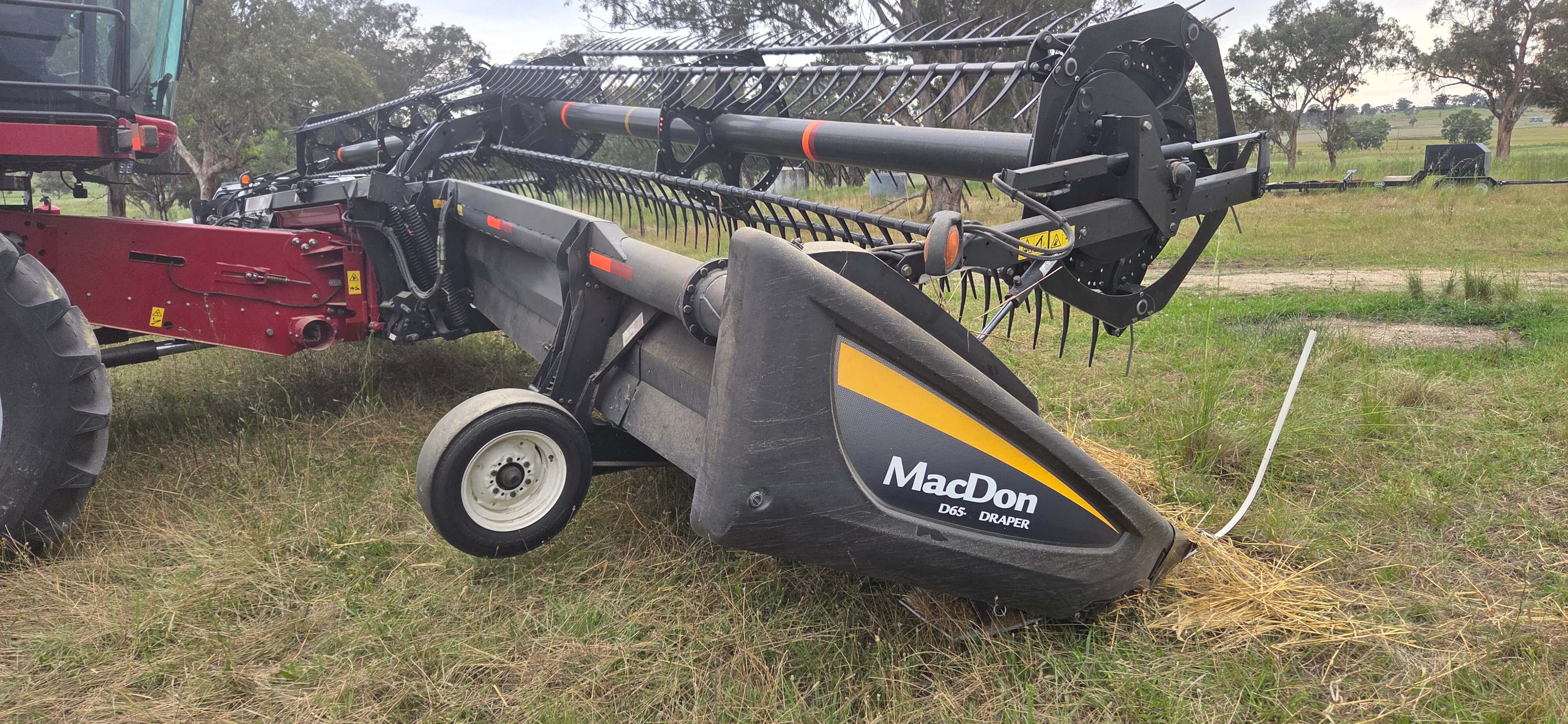 Damaged MacDon draper front showing collision damage to the cutter-bar and frame — the type of accident repair handled daily at the HFR Swan Hill workshop